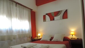 A hotel room with a bed, two bedside lamps, a painting on the wall, and a window with curtains. - Hotel Aldea Marina (Villa Gesell)