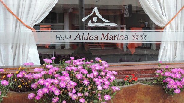 A hotel sign with a star symbol and the name 'Hotel Aldea Marina'. - Hotel Aldea Marina (Villa Gesell)