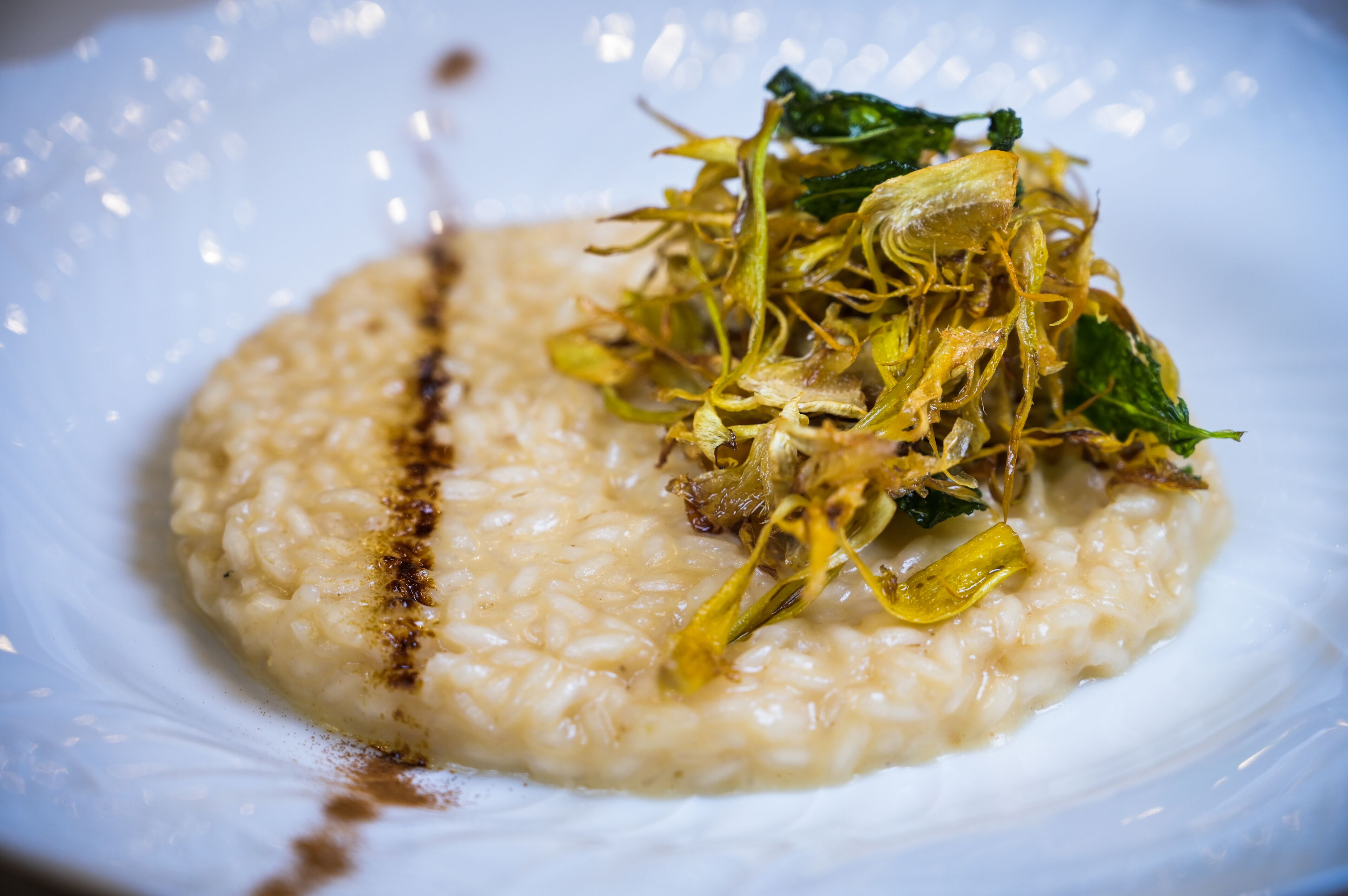 Eine Portion cremiges Risotto mit grünen Kräutern und möglicherweise Pilzen.