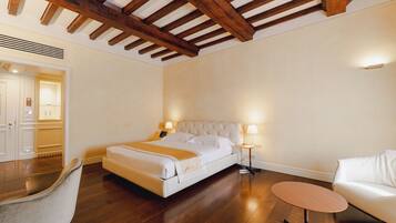 A hotel room with a bed, bedside tables, a chair, and a small table.