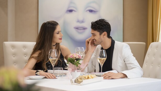 A dining table with a white tablecloth, two chairs, and a bouquet of flowers. - Hotel Rua Frati 48 in San Francesco (Modena)