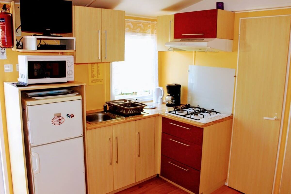 A compact kitchen with a microwave, stove, and refrigerator.