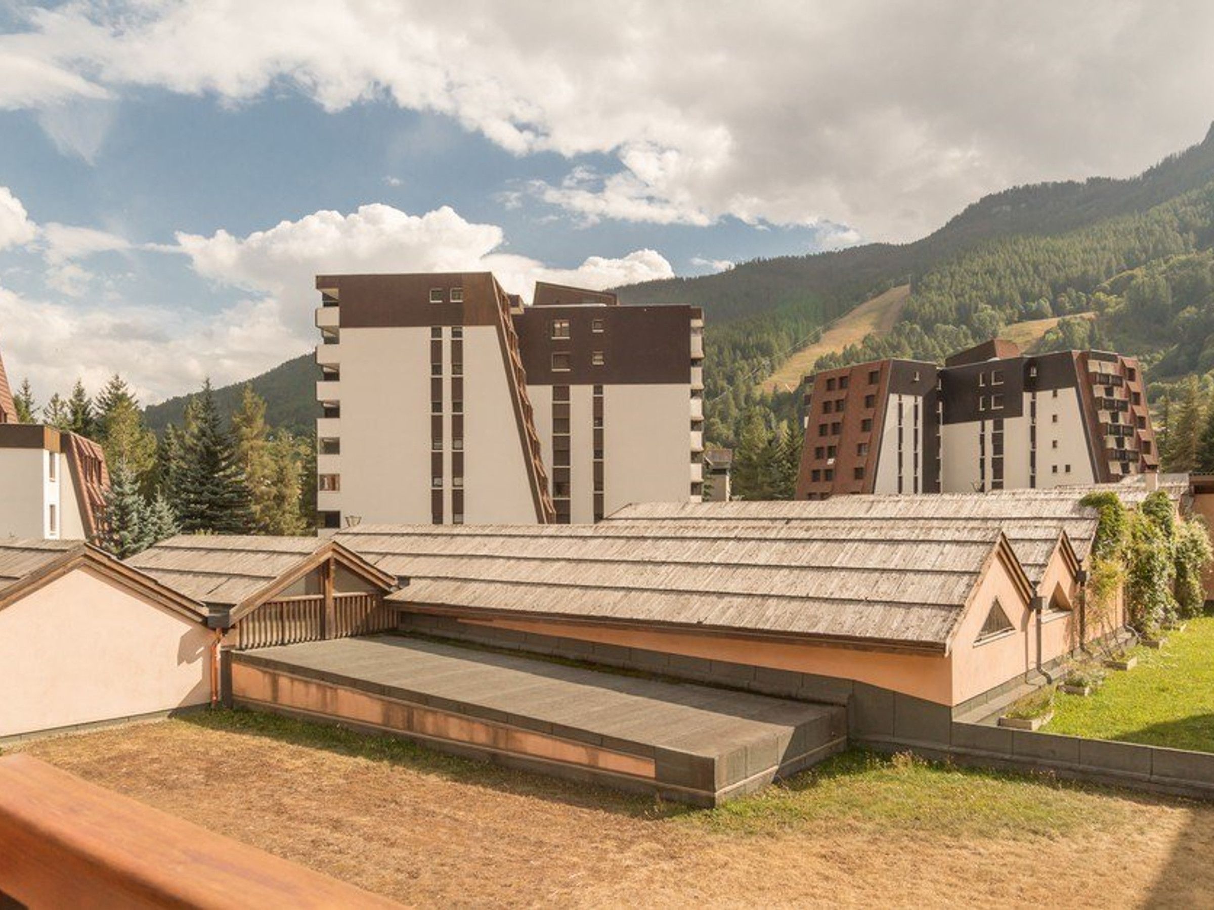 Ein modernes Hotel mit Flachdach und Blick auf eine gebirgige Landschaft.