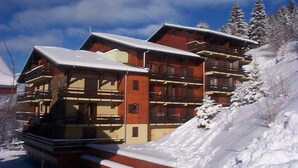 A multi-story lodge with balconies and a ski slope in the background. - 2-room apartment for 4 people with balcony in Châtel (Châtel)