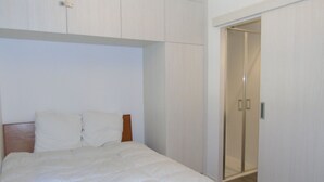 A bedroom with a bed, a wooden headboard, a white wall, and a sliding door closet. - Comfortable apartment in Châtel with balcony for 4 pers. (Châtel)
