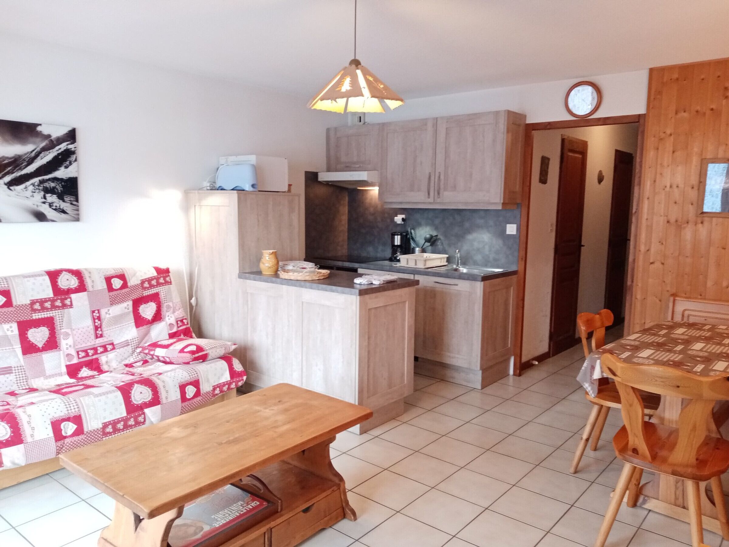 A compact living space with a kitchenette, a dining area, and a sofa.