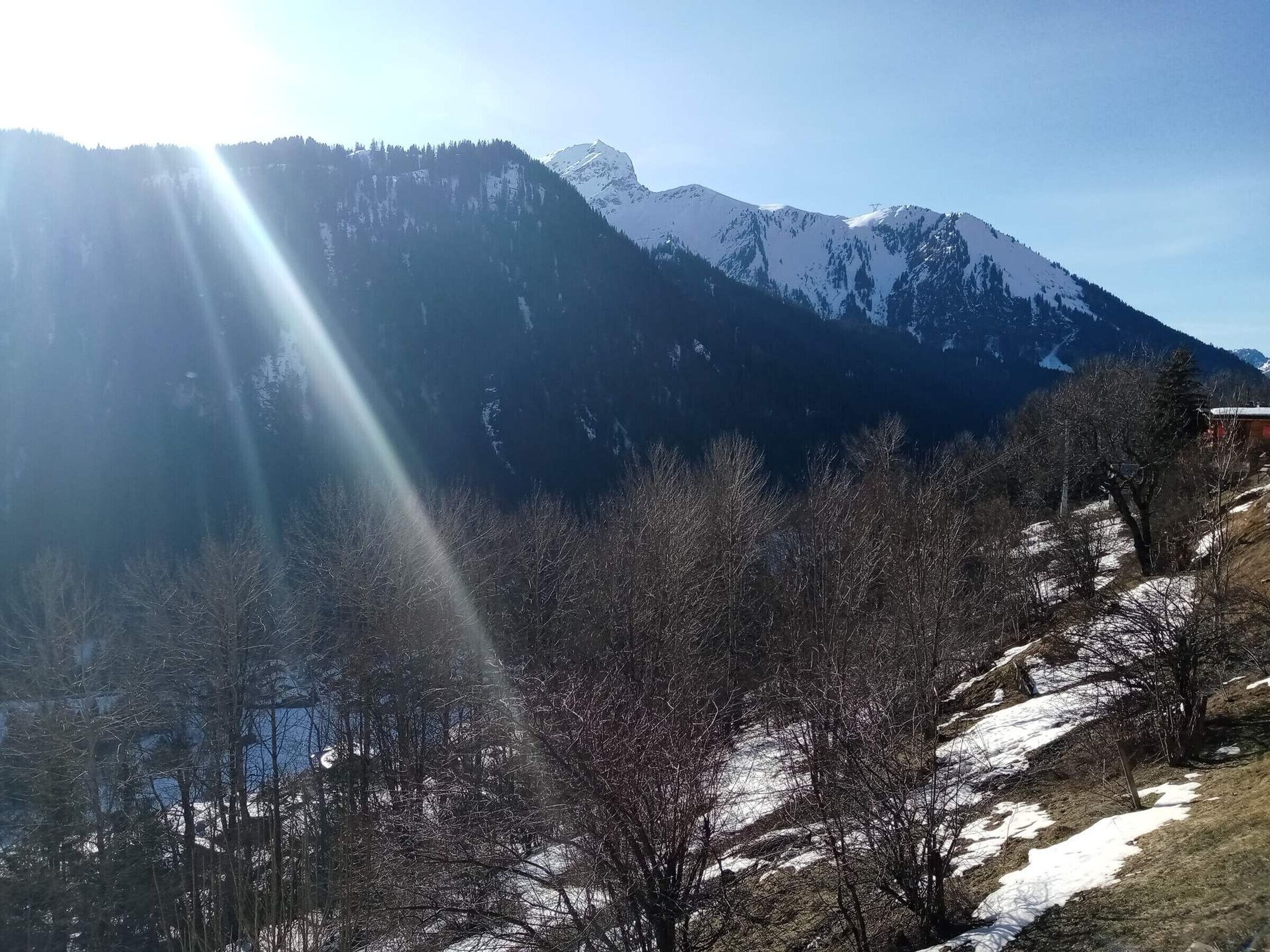 Un paysage montagneux aux sommets enneigés, sous un ciel dégagé.