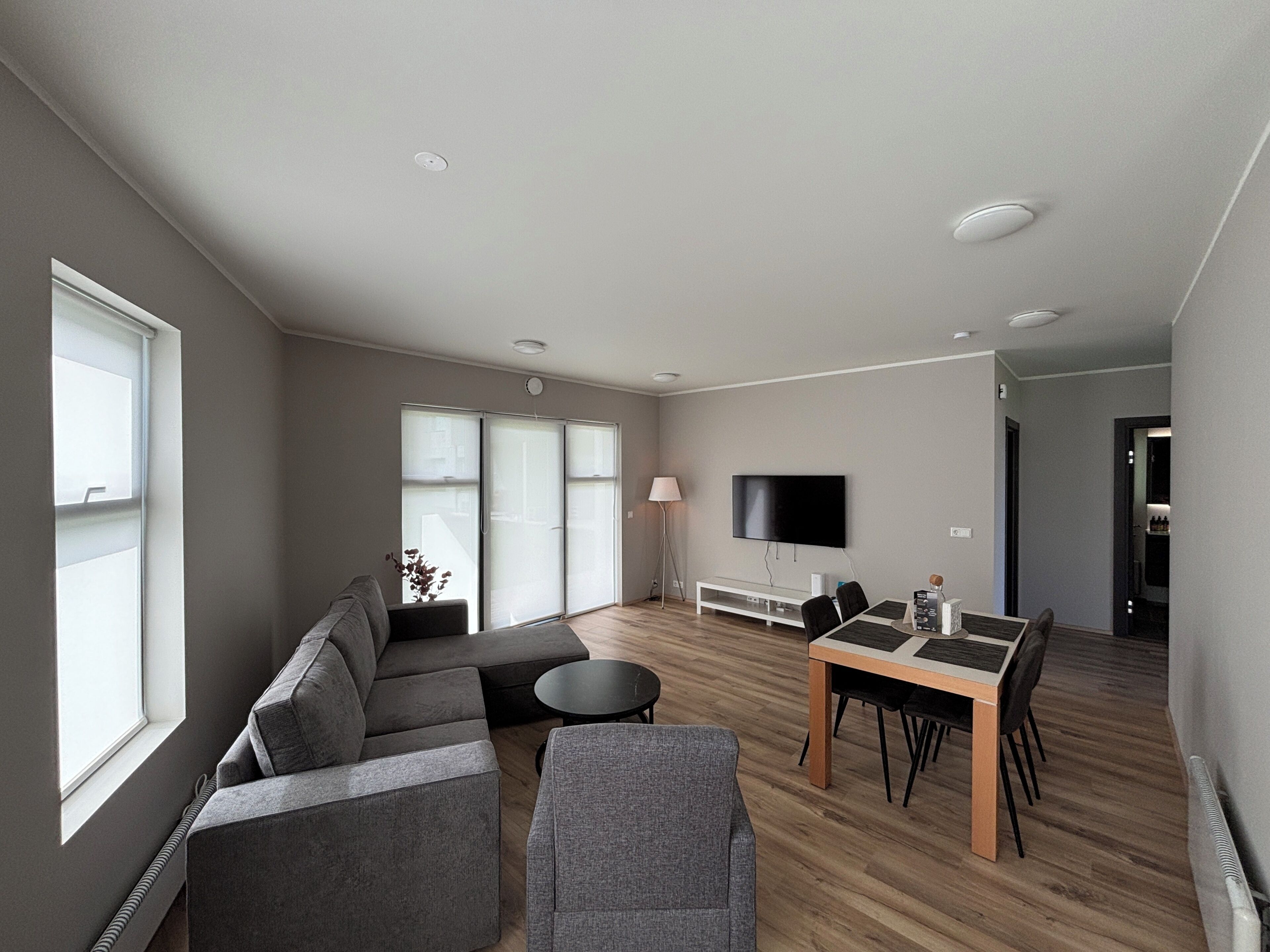 Una sala moderna con un sofá, una mesa de comedor y un televisor de pantalla plana.
