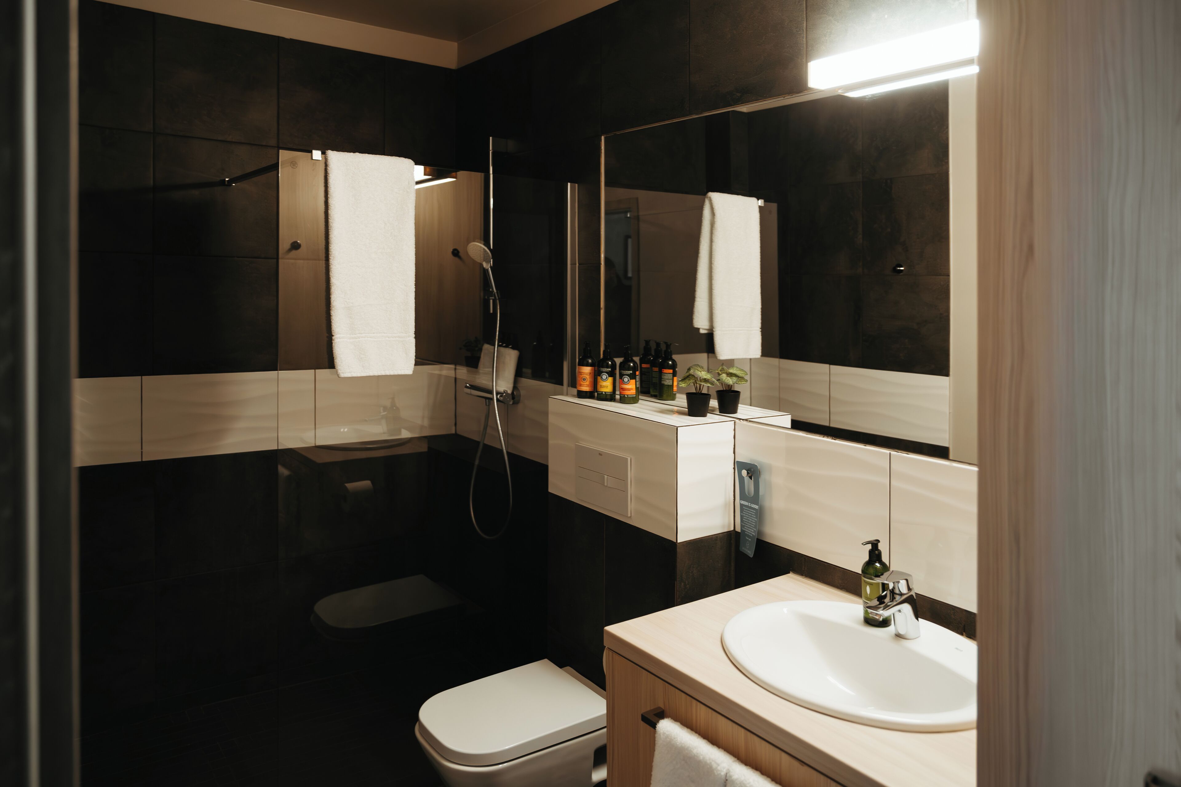 Un baño moderno con inodoro, lavamanos y ducha.