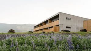 A modern building with a flat roof, multiple balconies, and a concrete facade. - Vík Apartments (Vik I Myrdal)