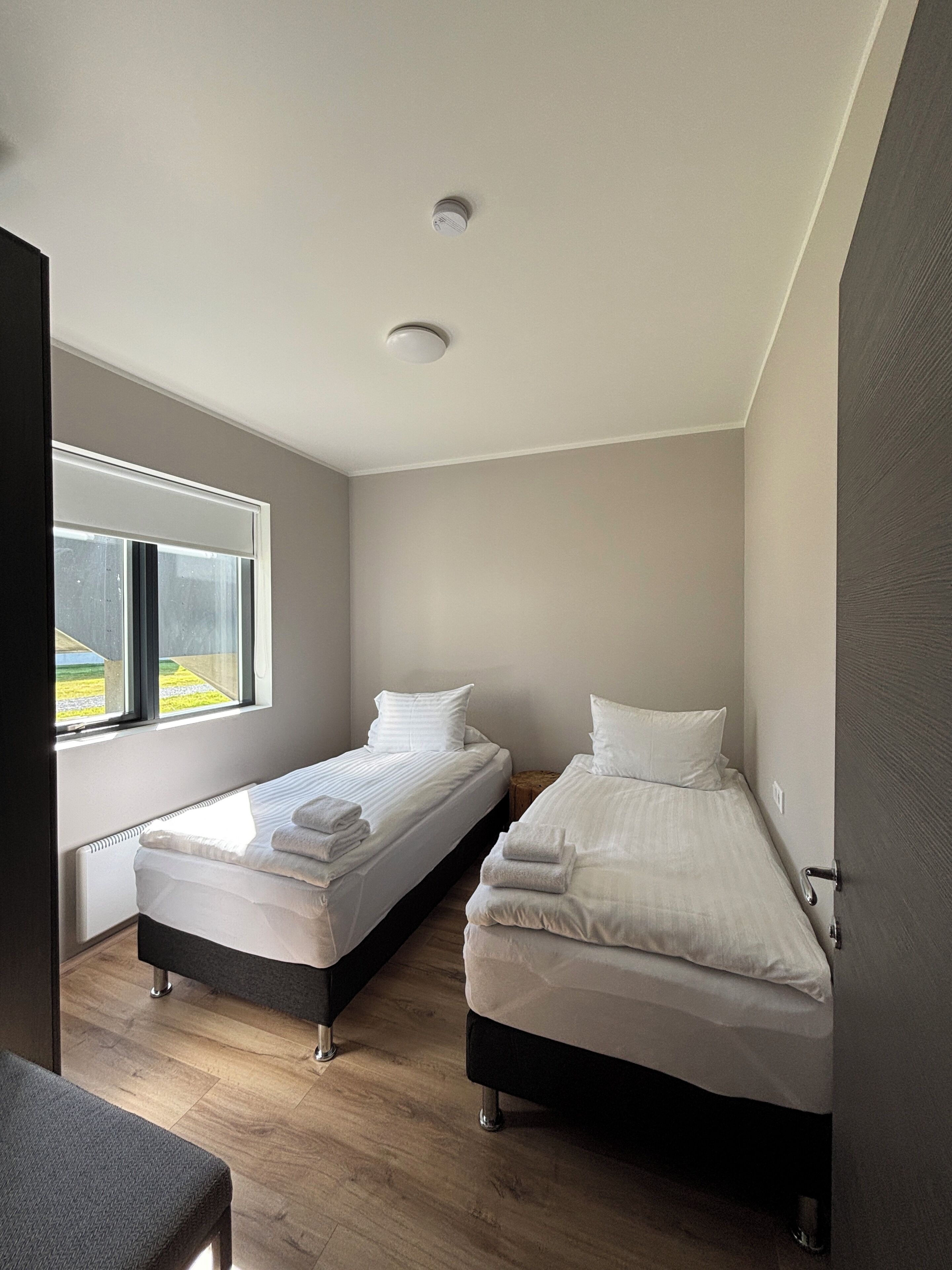 Una habitación con dos camas, una ventana y un radiador.