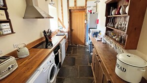 A kitchen with a washing machine, a kettle, and a bread container. - Drovers Retreat (Llandrindod Wells)