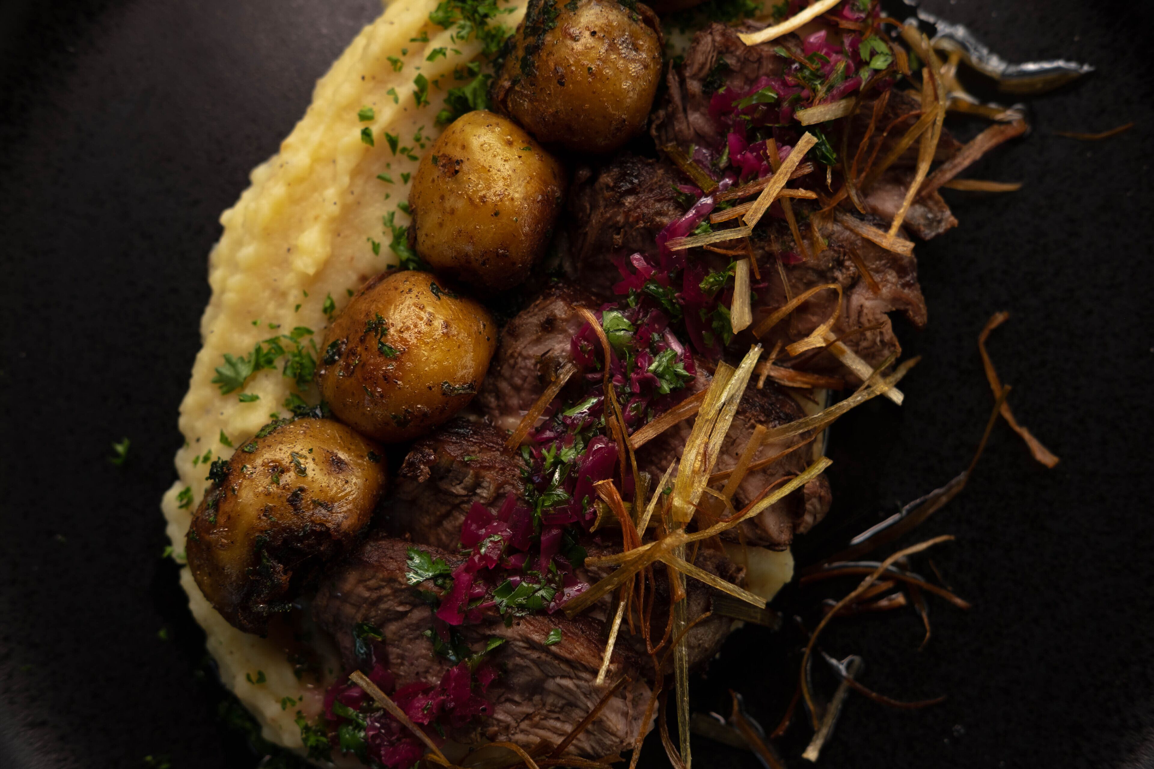 Ein Gericht mit Fleisch, Kartoffeln und Beilagen.