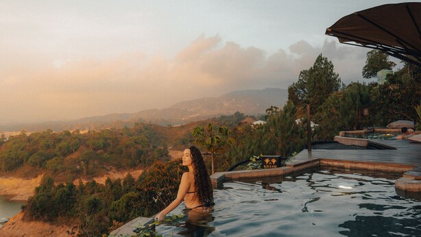 A person relaxing in a pool with a view of a mountainous landscape. - Bosko (Guatapé)