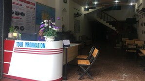 Ein Empfangsbereich mit einem 'Tour Information'-Schalter, einer Treppe und einer Karte an der Wand.