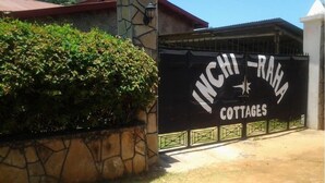 Een hekpoort met een bordje voor Inchi-Raha Cottages.