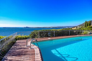 Una piscina al aire libre de temporada, sombrillas