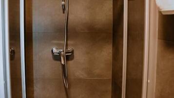 Eine begehbare Dusche mit Duschbrause, Handfaucet und Bedienfeld.