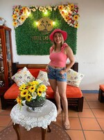 Una mujer de pie en una habitación con una pared verde, un letrero que dice 