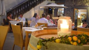 A restaurant setting with tables, chairs, and a candle centerpiece.