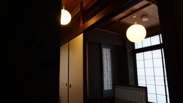 Une pièce de style japonais traditionnel, avec un sol recouvert de tatamis, des portes coulissantes et un paravent shoji.