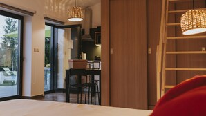 A hotel room with a large bed, a dining area with chairs, and a staircase. - Lugar nas Estrelas (Covilhã)
