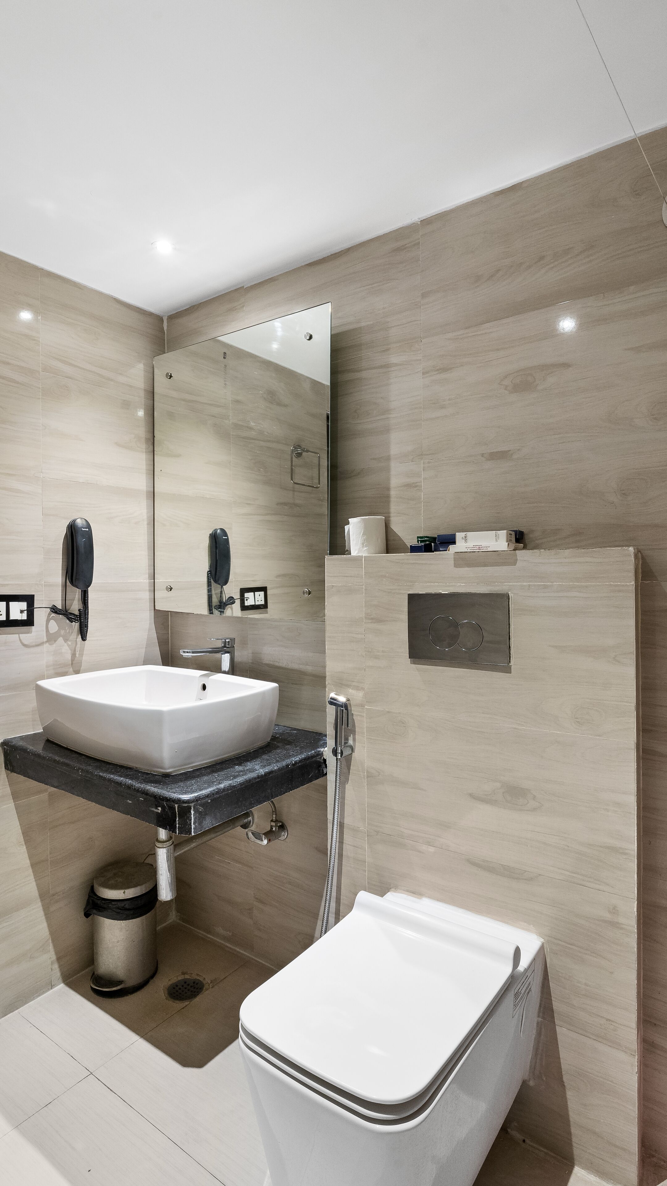 A modern bathroom with a sink, mirror, and toilet.