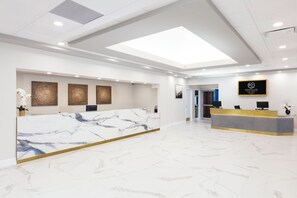 A hotel reception area with a marble reception desk, a digital screen, and a sign for Westgate Palace Resort. - Westgate Palace (Orlando)