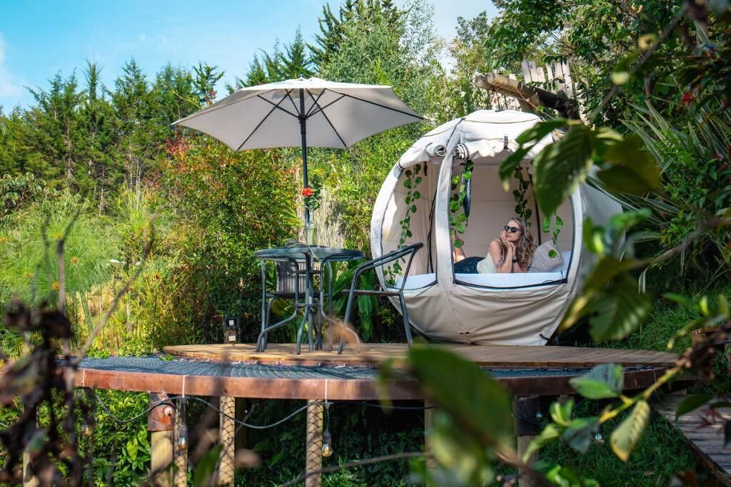 A cozy outdoor seating area with a round table, chairs, and a canopy umbrella.