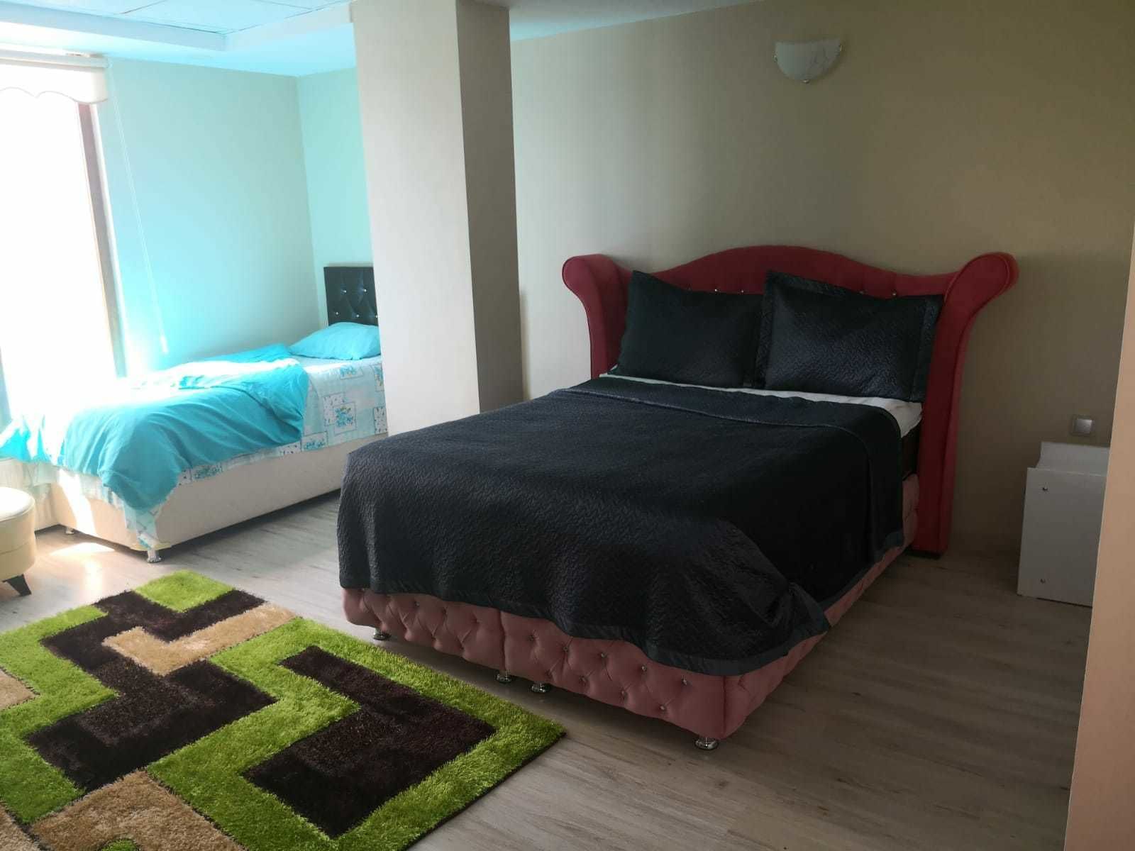 A bedroom with a bed, a nightstand, a chair, and a rug.