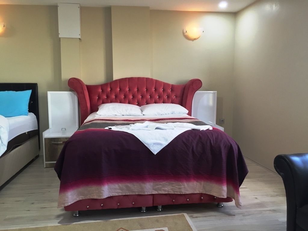 A hotel room with a large bed, two bedside tables, and a chair.