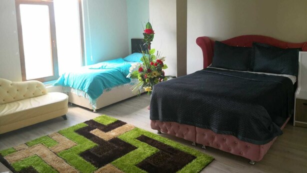 Un dormitorio con cama, una silla, un escritorio y ventana.