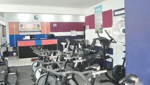 A gym with stationary bikes, a reception desk, and exercise equipment.