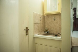 Un baño con un lavabo, un mueble encima y una puerta.