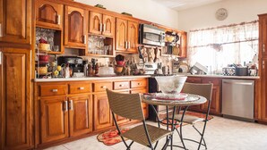 A kitchen with wooden cabinets, a microwave, and various kitchen items. - Jewel In The Sand (Runaway Bay)