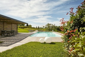 A swimming pool with a patio area, outdoor seating, and a covered section. - L'Uva e le stelle (Faedis)