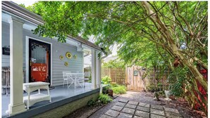 A covered patio with a table and chairs, a wooden fence, and a garden area. - PEACEFUL PRIVATE COTTAGE-WALK TO PARK-5 MINS TO DOWN TOWN (Nashville)