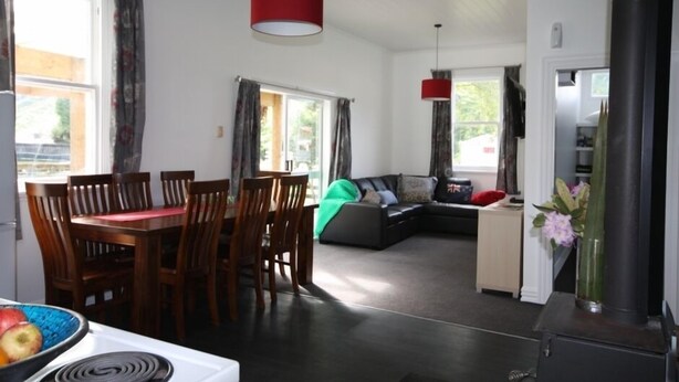 A modern living space with a dining area, a sofa, and a fireplace.