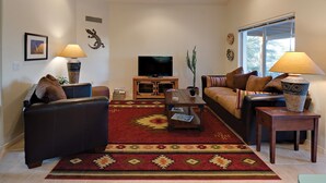 A living room with a sofa, a coffee table, a TV, and decorative items.