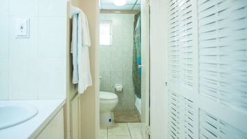A bathroom with a toilet, sink, and shower area.