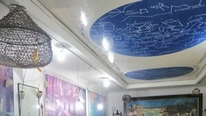 A museum interior with exhibits, a large mural, and a tiled floor. - La Perle Bleue (Le Kram)