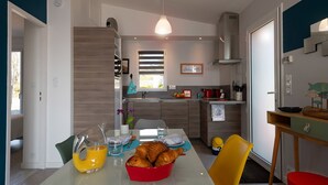 Eine moderne Küche mit Essbereich, ausgestattet mit einer Frühstücksvorrichtung mit Croissants und Orangensaft.
