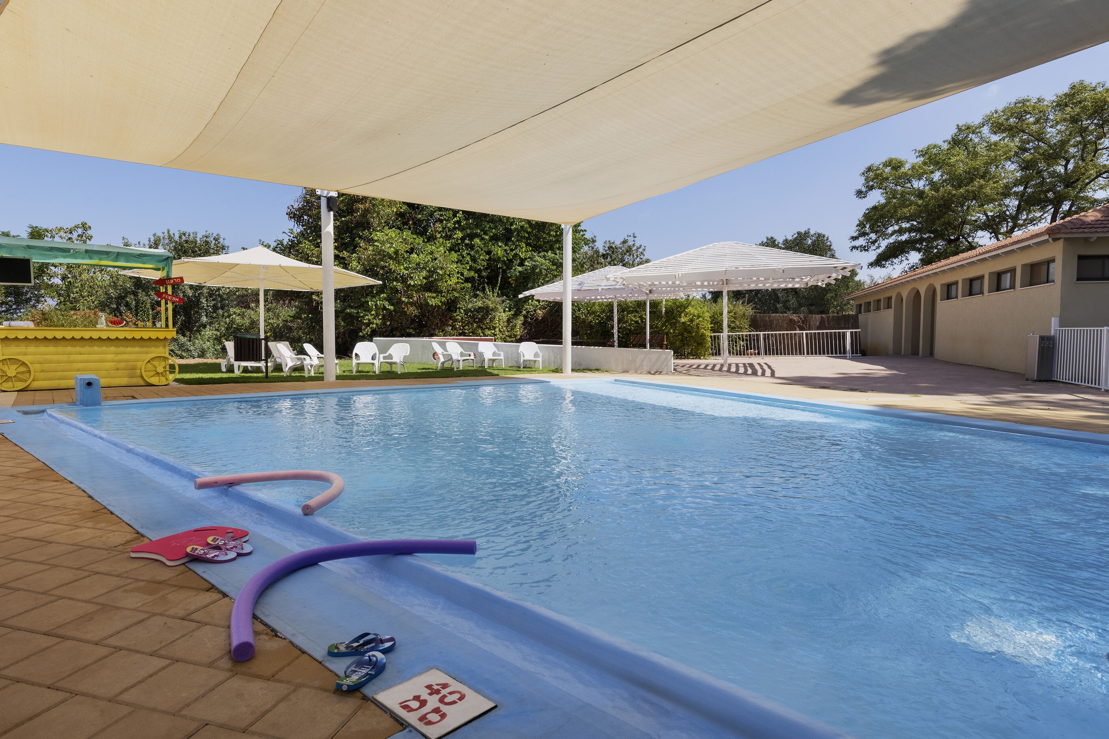 Een seizoensgebonden buitenzwembad en ligstoelen