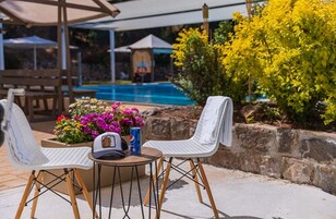 Una piscina al aire libre de temporada, sillones reclinables de piscina