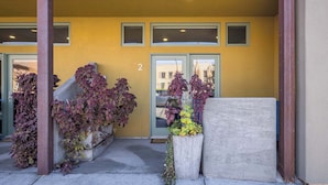 A building entrance with a yellow wall, numbered '2', and a set of steps leading up to it. - Downtown Hideaway in the Heart of Moab #2 (Moab)