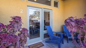 A building entrance with a numbered door, a glass door, and blue chairs outside. - Downtown Hideaway in the Heart of Moab #2 (Moab)