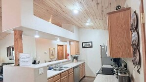 Une cuisine moderne avec des meubles en bois, un îlot central et un four encastré.