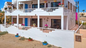 A two-story white building with balconies, windows, and outdoor plants. - Ocean view 6 bedroom 4 bath 3500 square foot  (Puerto Penasco)