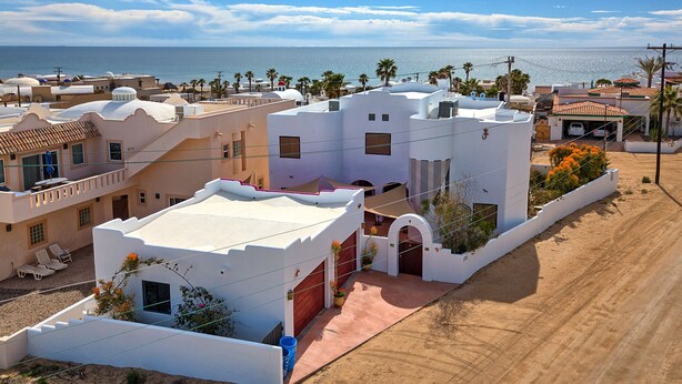 A coastal residential area with white buildings, a sandy road, and a view of the sea. - Ocean view 6 bedroom 4 bath 3500 square foot  (Puerto Penasco)