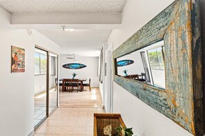 Enter a welcoming hallway leading to a dining area with a wooden table and chairs.